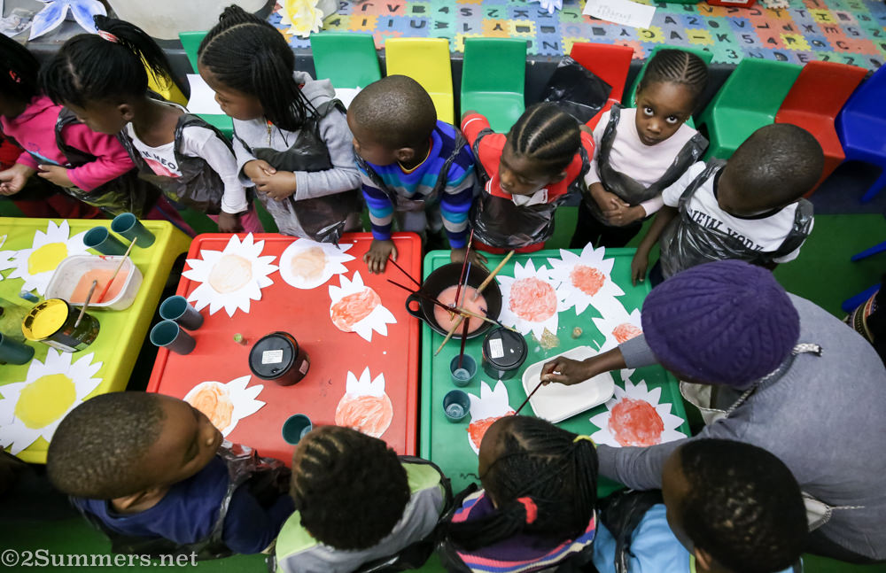 Birds-eye view of kids painting at Grow Up and Learn School