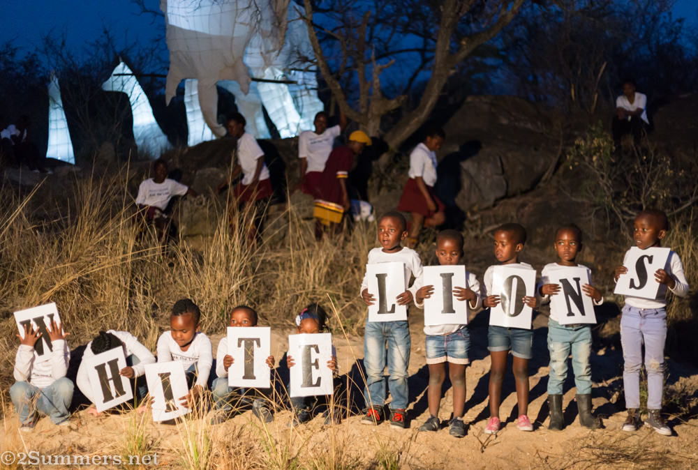 Little kids with white lions sign