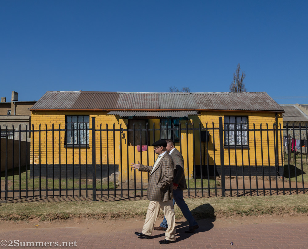 Men walk past a house in Noordgesig