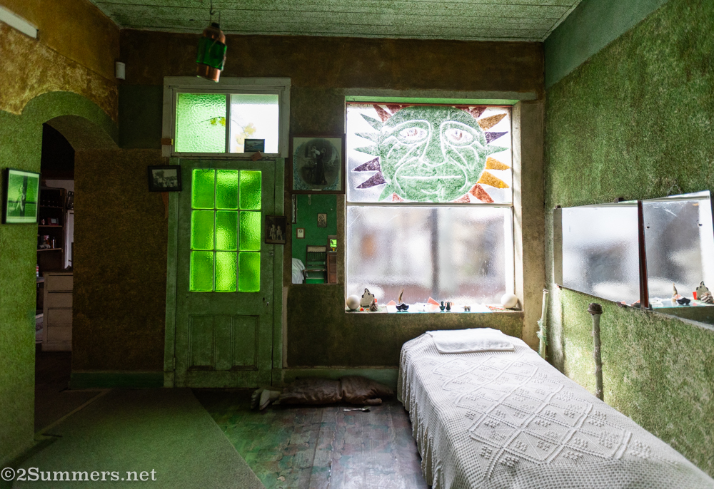 Green bedroom with creepy sculpture